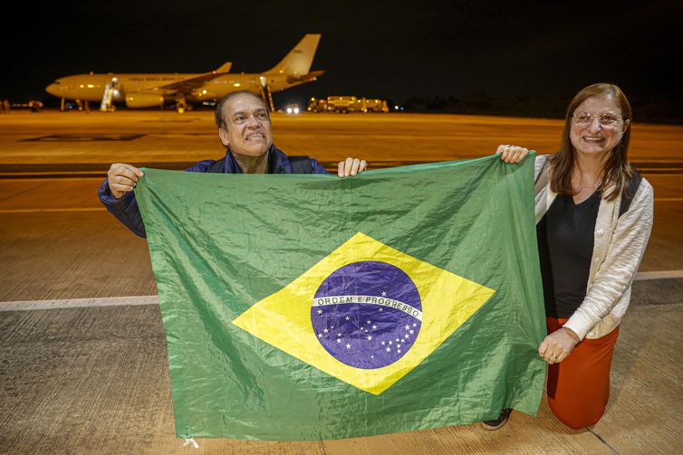 Brasília – Roberto Carvalho e sua companheira Cristina Balbi se ajoelham para agradecer a chegada ao Brasil no primeiro avião da FAB trazendo 211 brasileiros de Israel - Foto Joédson Alves/Agência Brasil